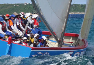 sonic crew up on the side of their boat during a tack