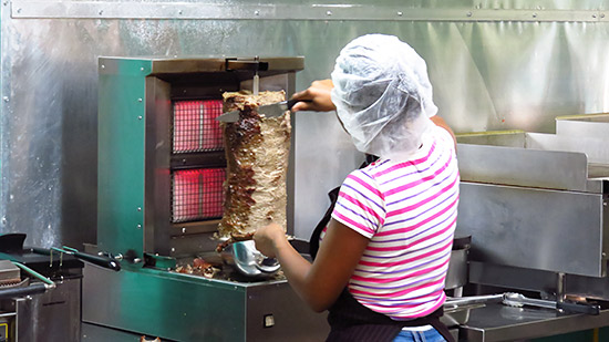 cutting the meat off the spit at zack shwarma