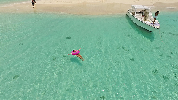 floating in the water around sandy island