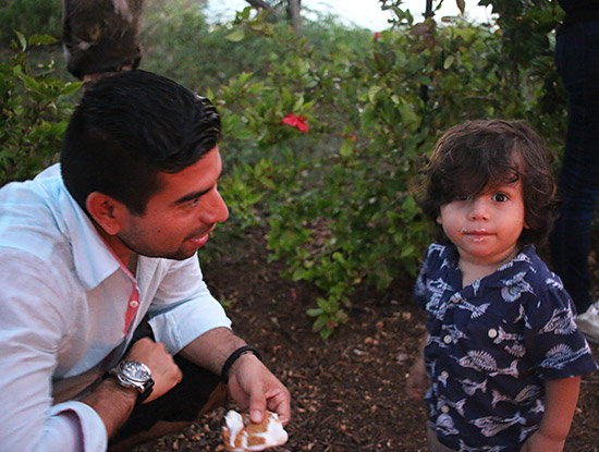 little kid taking his first bite of a smore