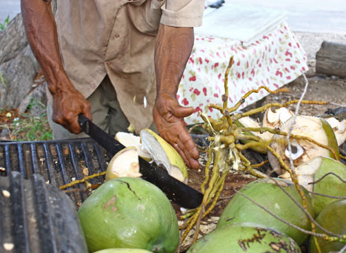 The coconut vendor slicing open a coconut