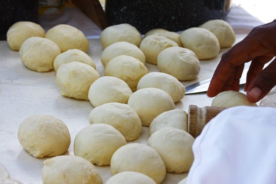 The rolling up of the dough to make Johnny Cakes